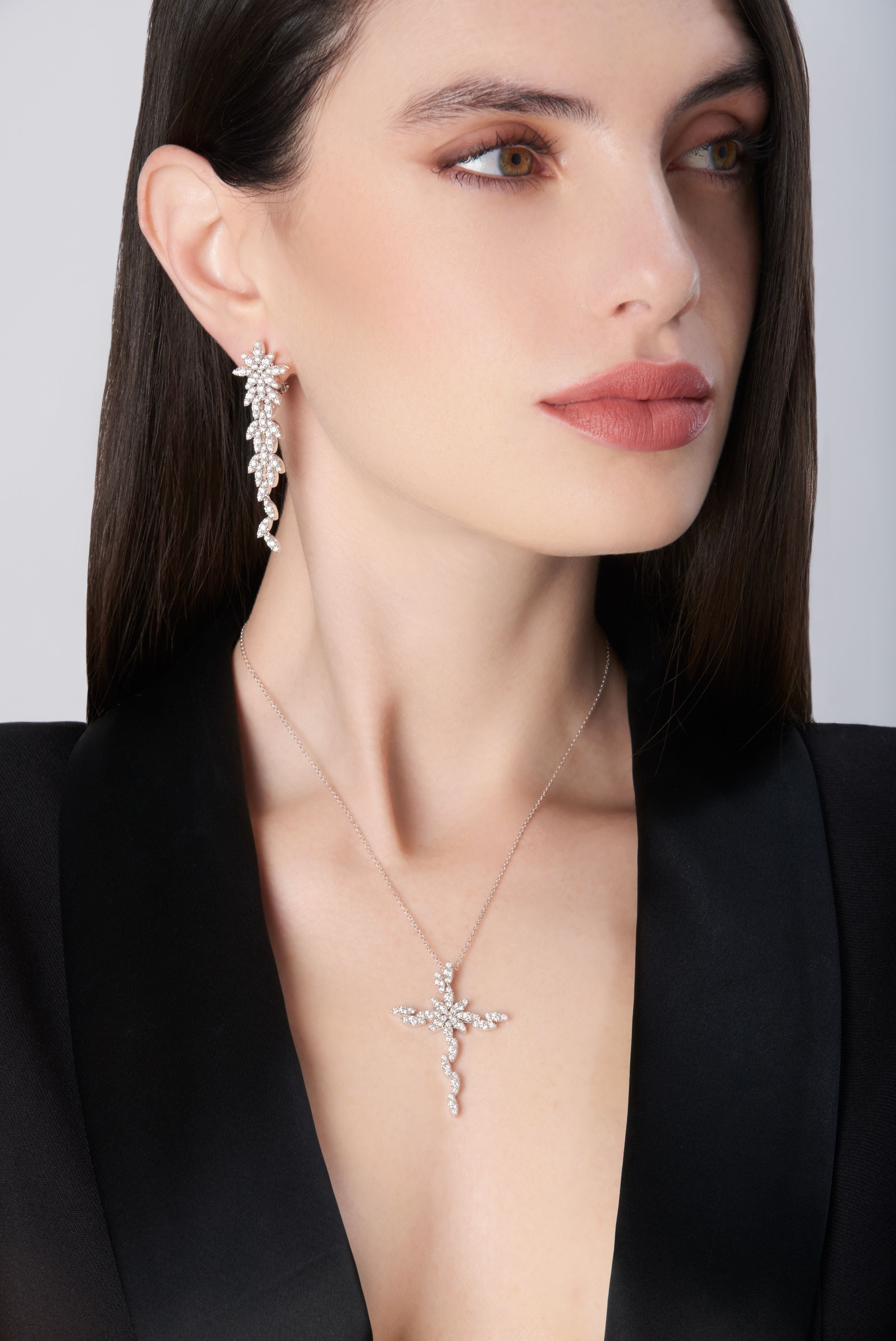 Pendant earrings and necklace with diamonds in 18k white gold worn by model in black jacket