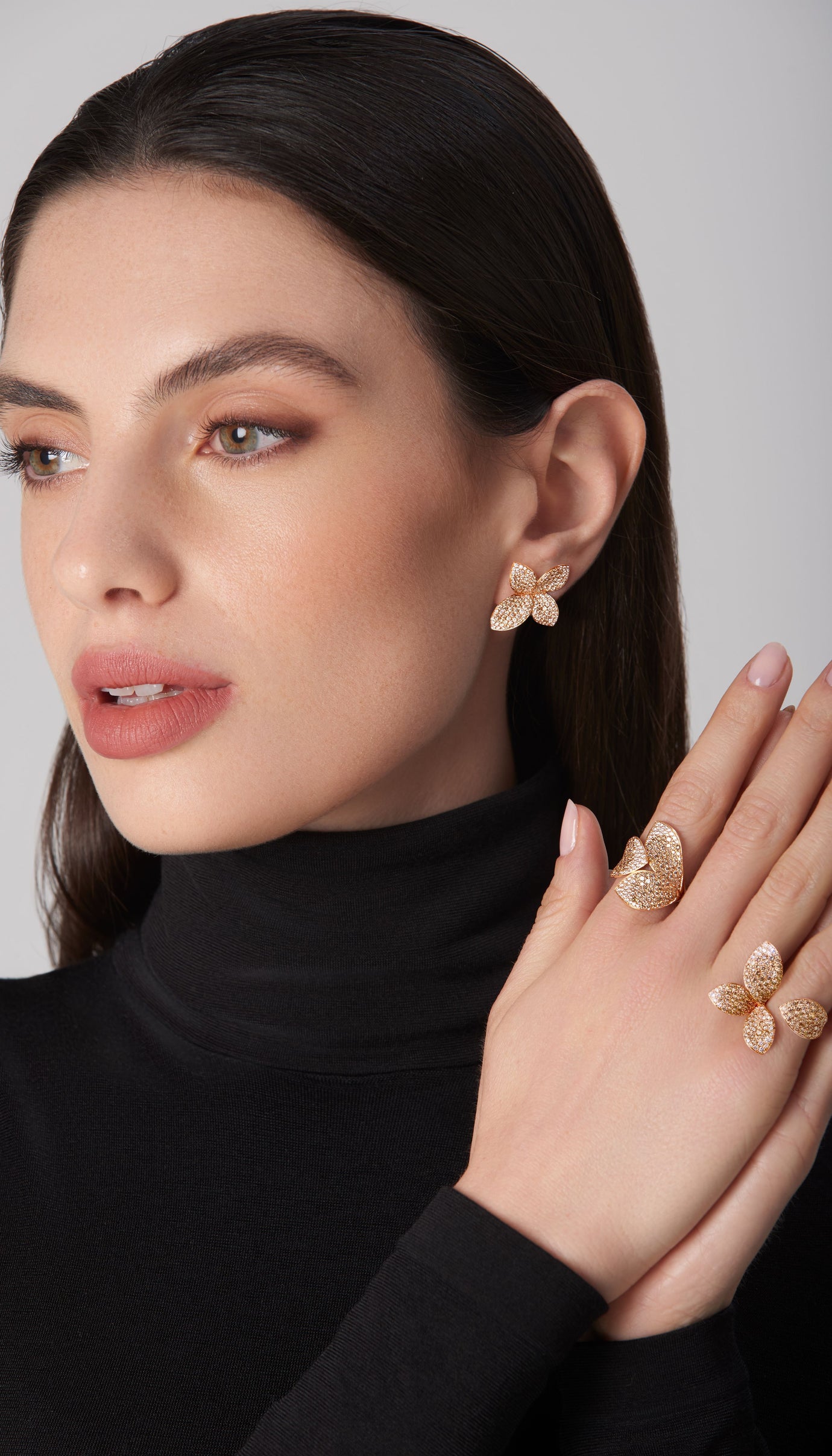 Earring and rings in 18k rose gold with diamonds worn by model in black turtleneck