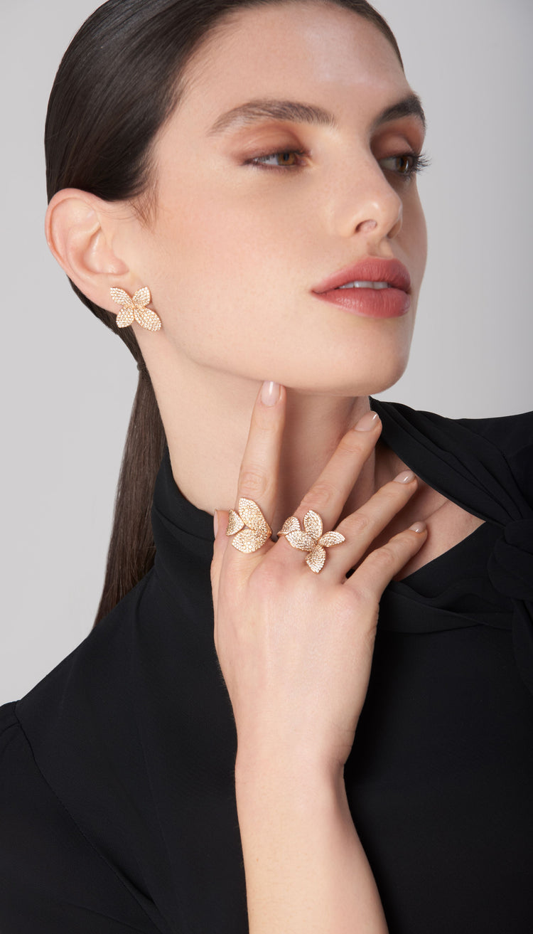 Earrings and rings in 18k rose gold with pavé diamonds on model wearing black blouse