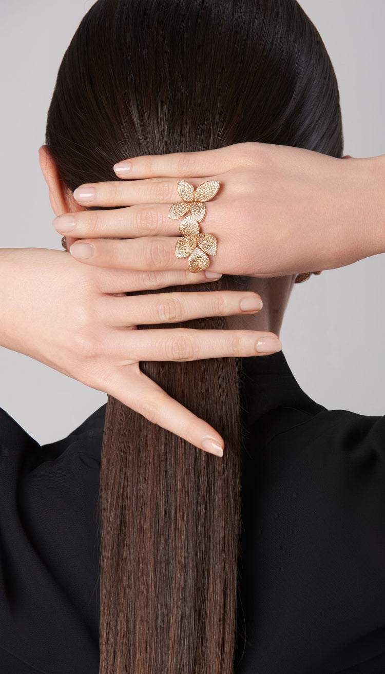 Rings in 18k rose gold with diamonds worn by a model wearing a dark blouse