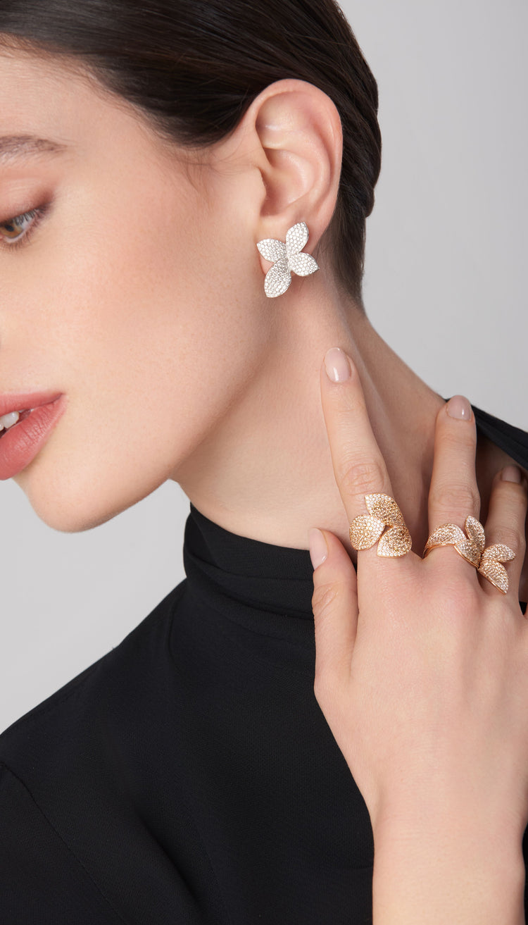 Earrings and rings in 18k gold with diamonds on model in black turtleneck