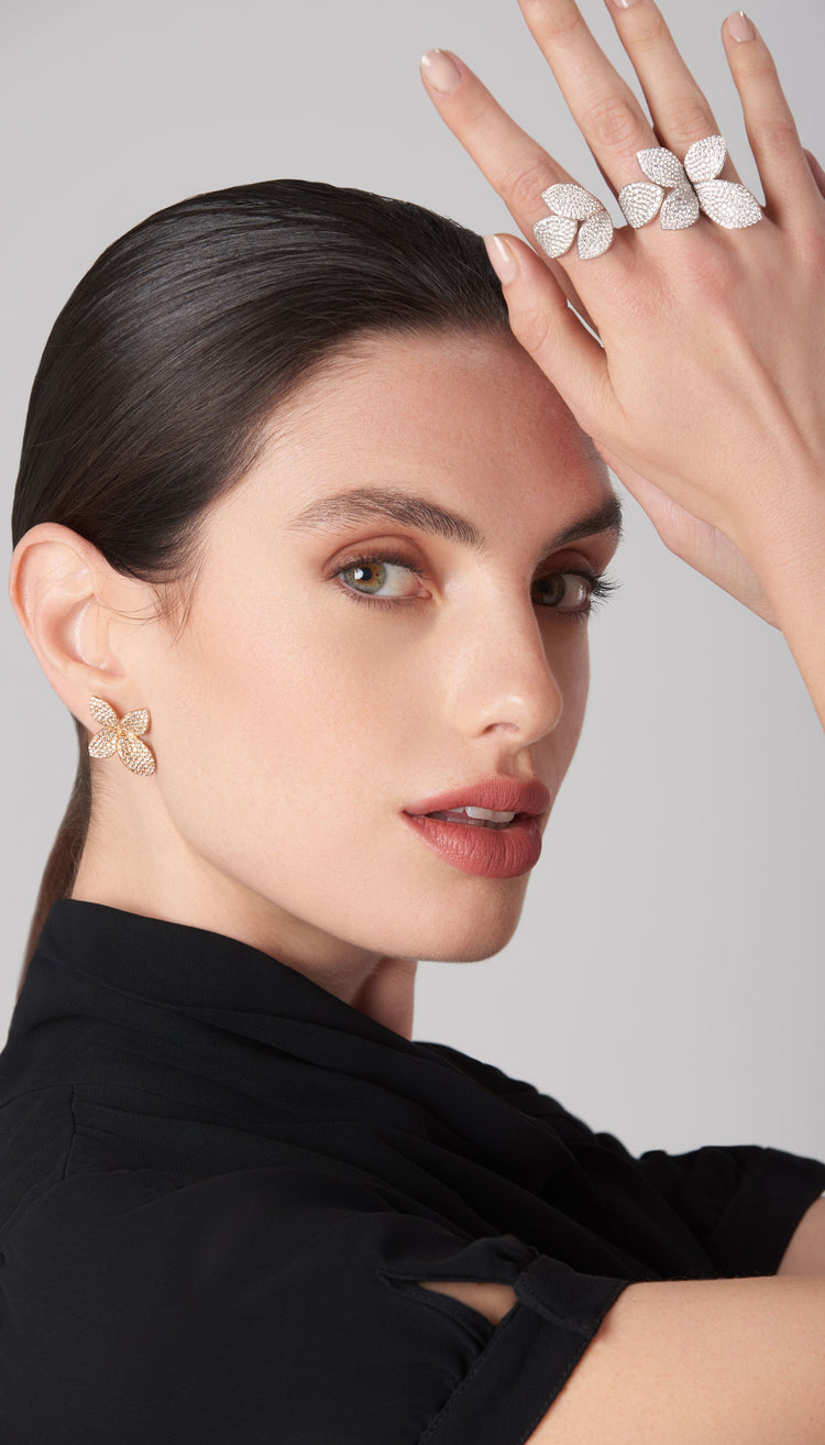 Earring and rings in 18k white and rose gold with diamonds worn by a model in a black silk blouse
