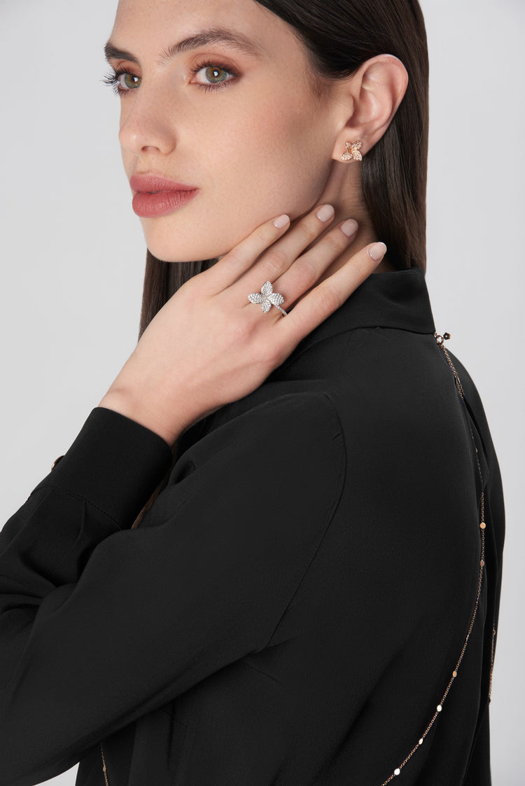 Earrings in 18k rose gold and diamond ring 18k white gold worn by a model in black blouse