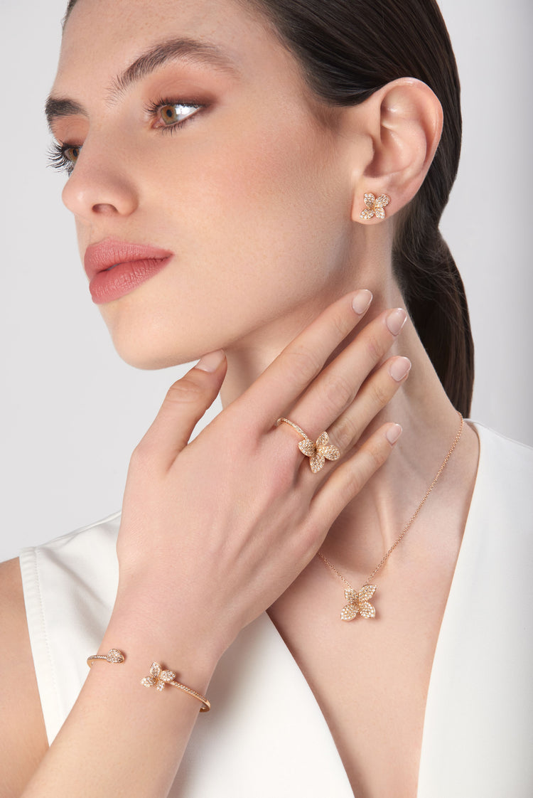 Earrings, bracelet, necklace and ring in 18k rose gold with diamonds on model in white dress