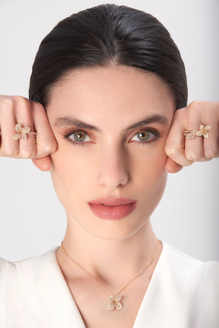 Necklace and rings in 18k rose gold with diamonds on model in white blouse