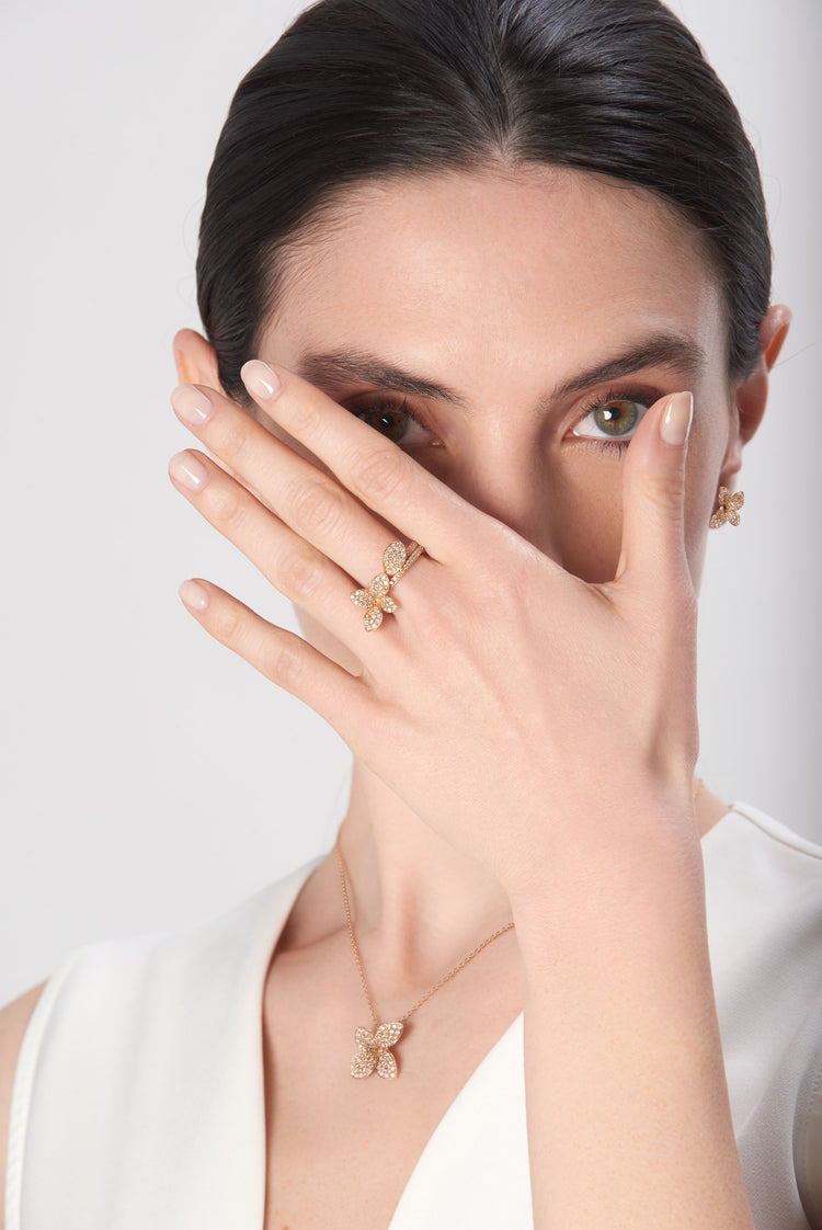 Necklace and rings in 18k rose gold with diamonds on model wearing ivory dress