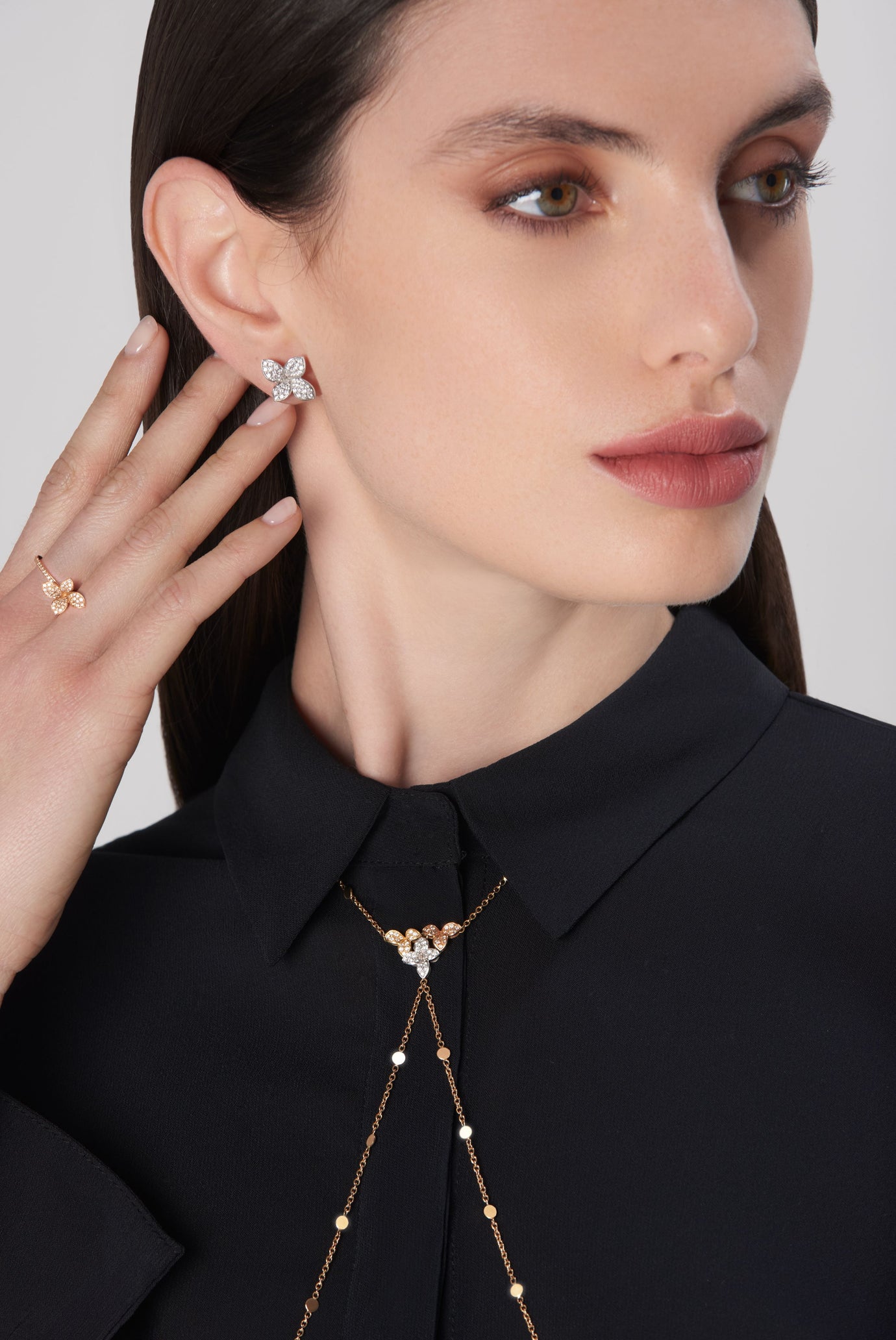 Earrings, ring and body chain in 18k rose gold and white gold with diamonds on model in black blouse