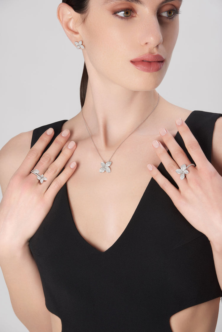 Necklace, earrings, and rings with diamonds in 18k white gold on model in black dress