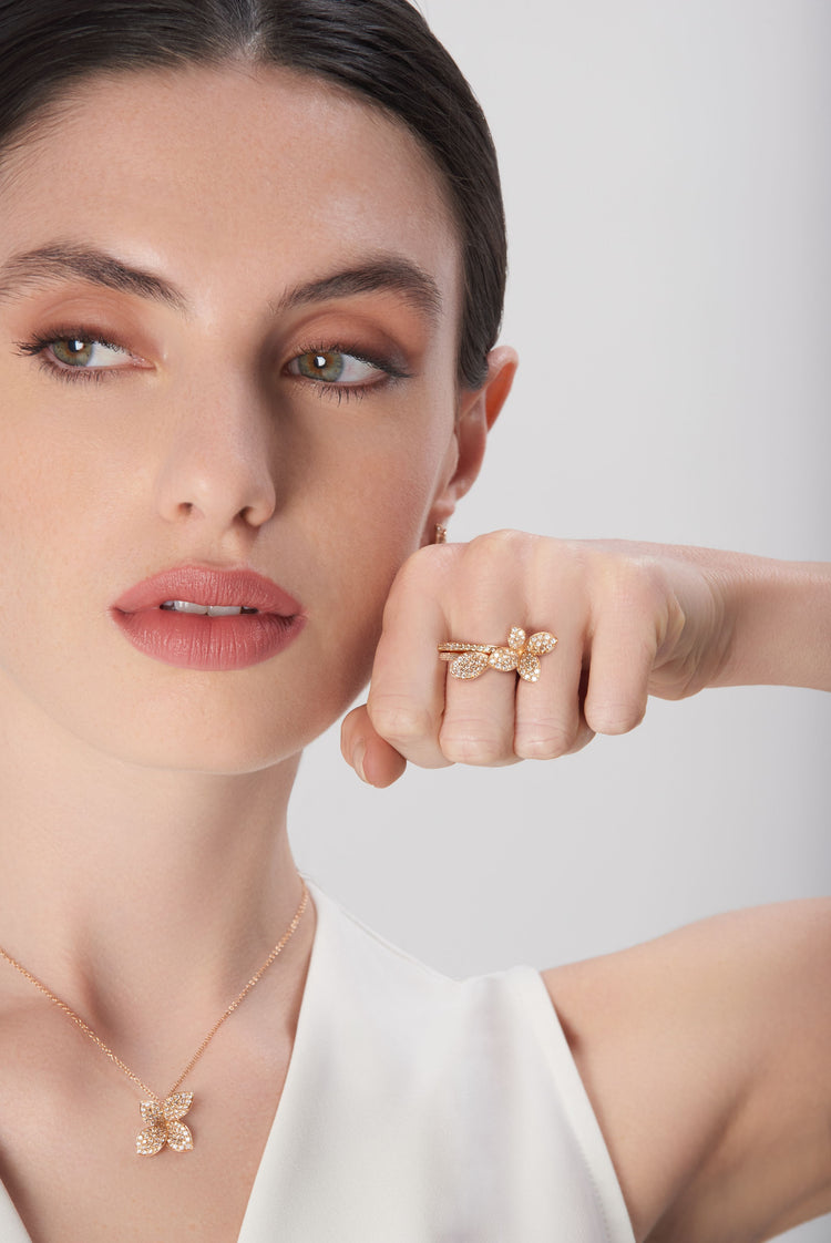 Necklace and rings in 18k rose gold with diamonds on model wearing white dress