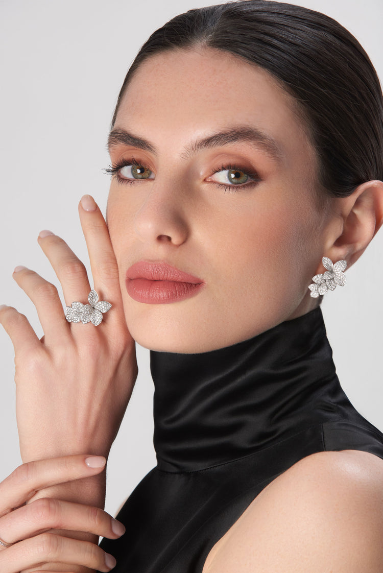 Earrings and ring in 18k white gold with diamonds, worn by woman in black silk turtleneck