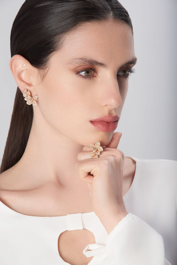 Earrings and ring in 18k rose gold with diamonds on model in white dress