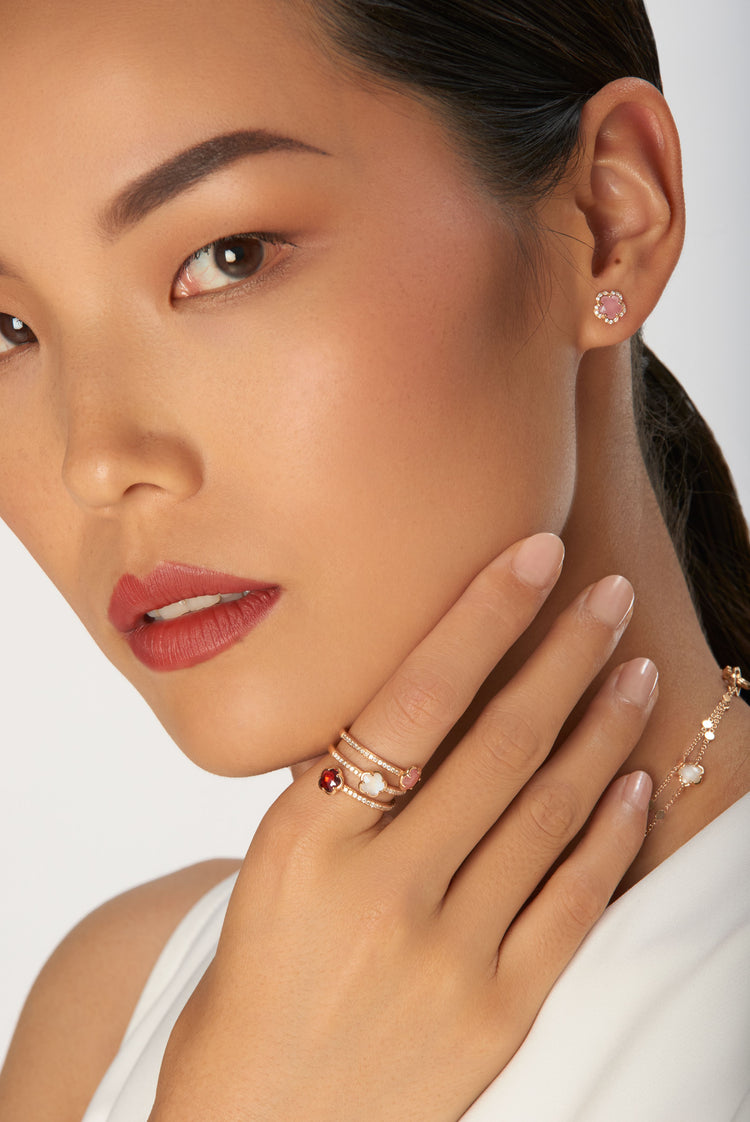 Stud earrings and rings in 18k rose gold with gemstones and diamonds on model in white dress