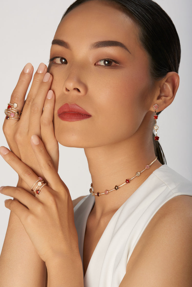 Choker, rings and earrings in 18k rose gold with gemstones and diamonds on model in white dress