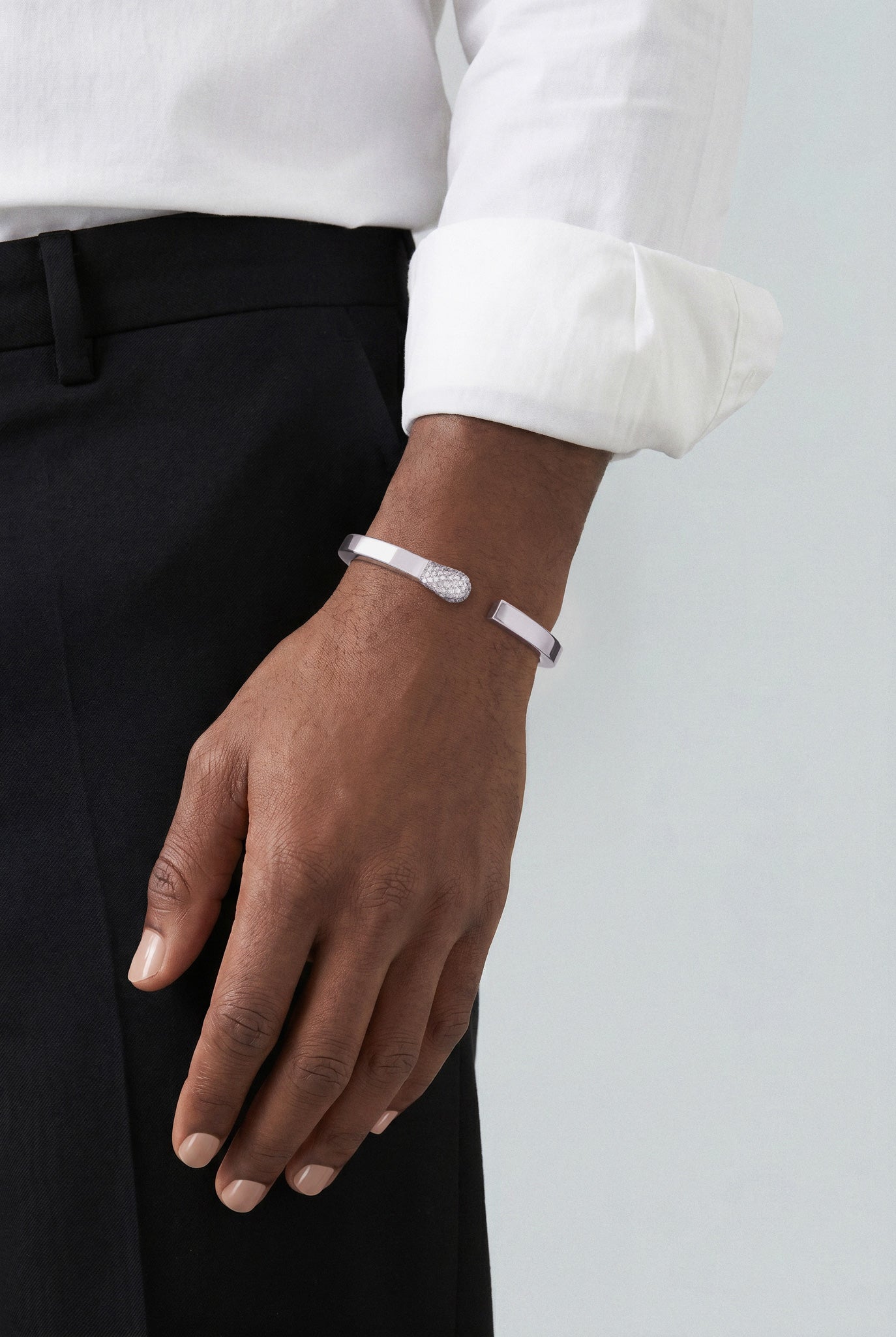 Model wearing a Bracelet in 18k White Gold with White Diamonds and a white shirt and black pants