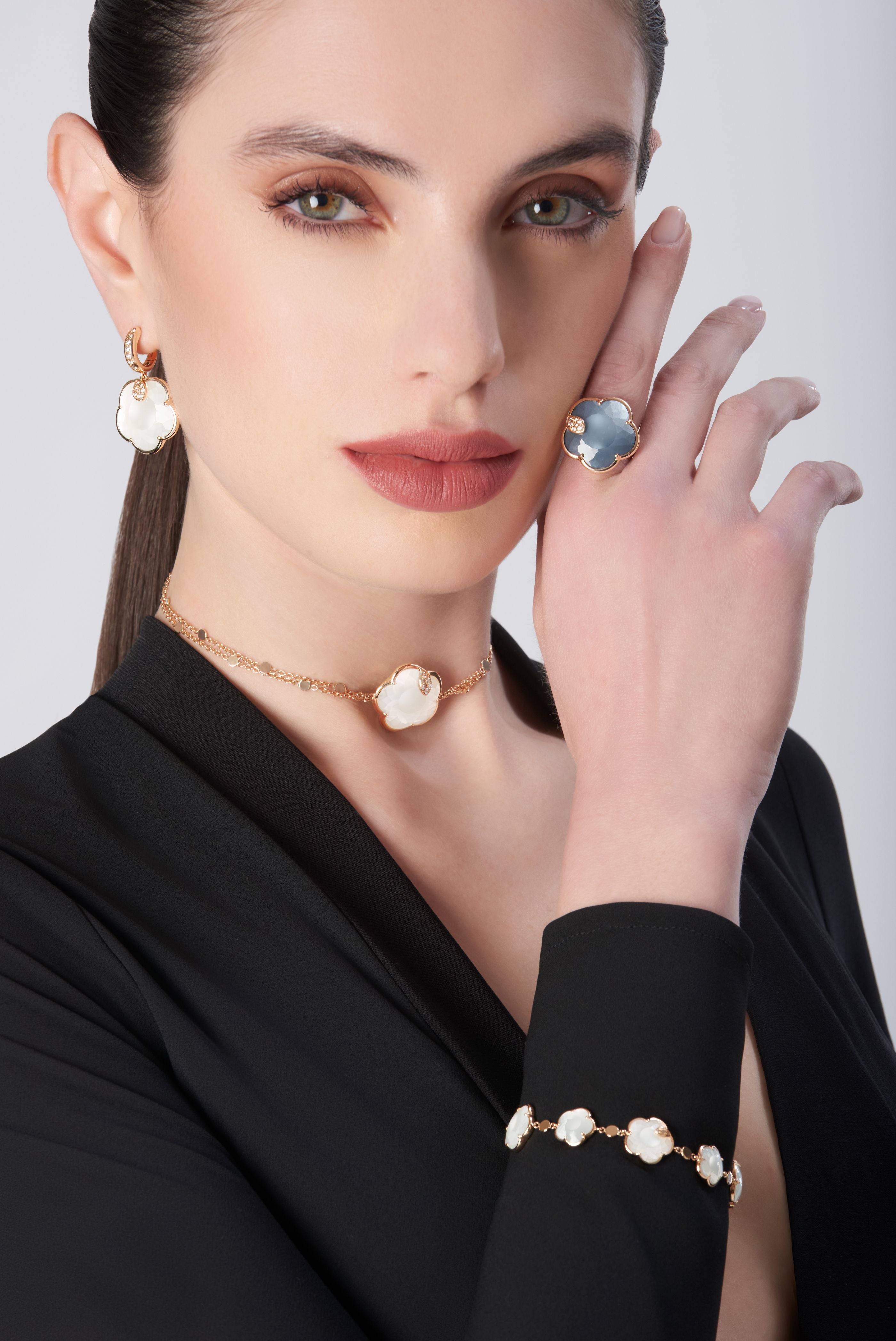 Model wearing earrings, necklace, ring, and bracelet in 18k gold withPearl of The Moon Gem and Diamonds, with a black blouse
