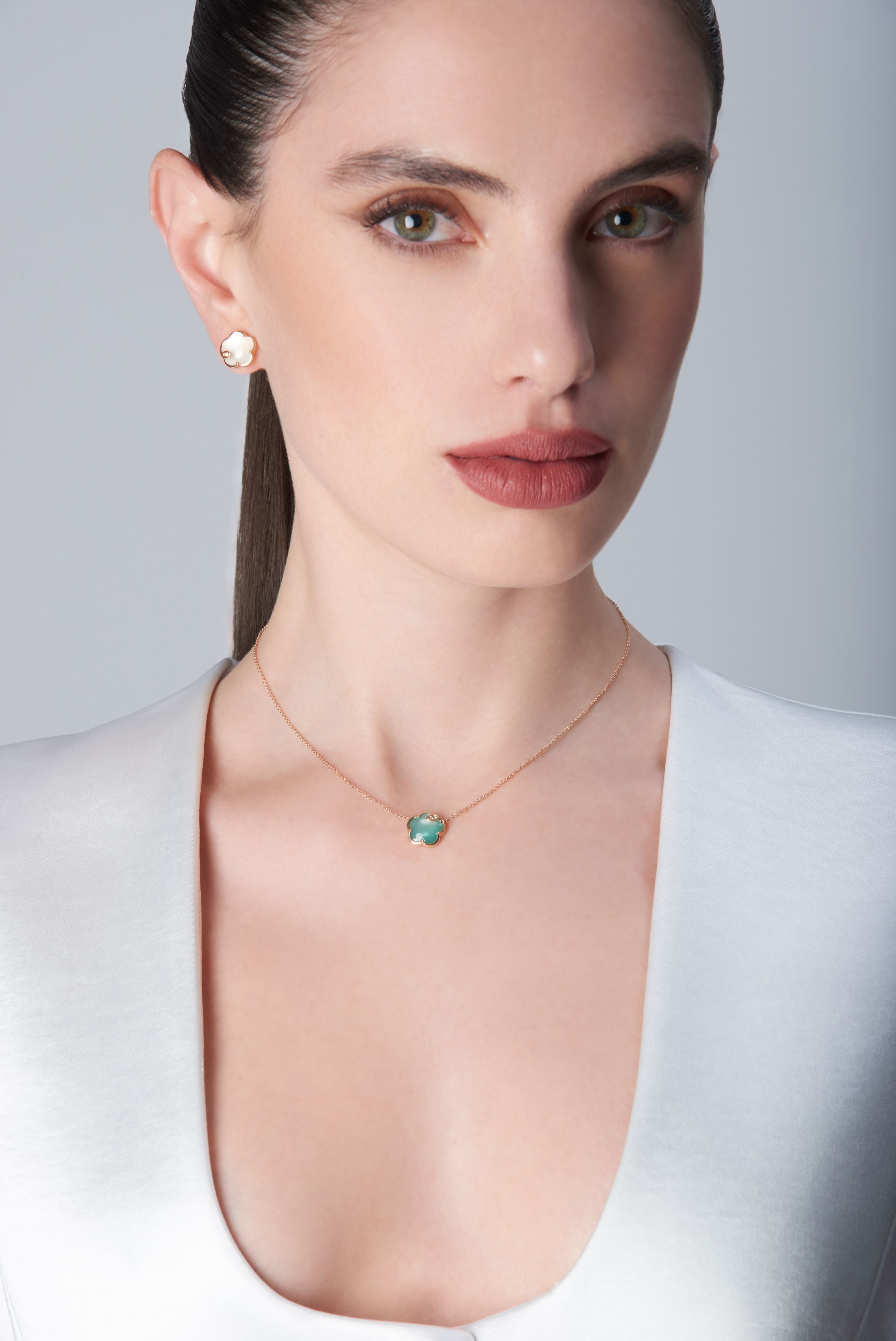 Combination of necklace and earrings in 18k Rose Gold with coloured gems on model.