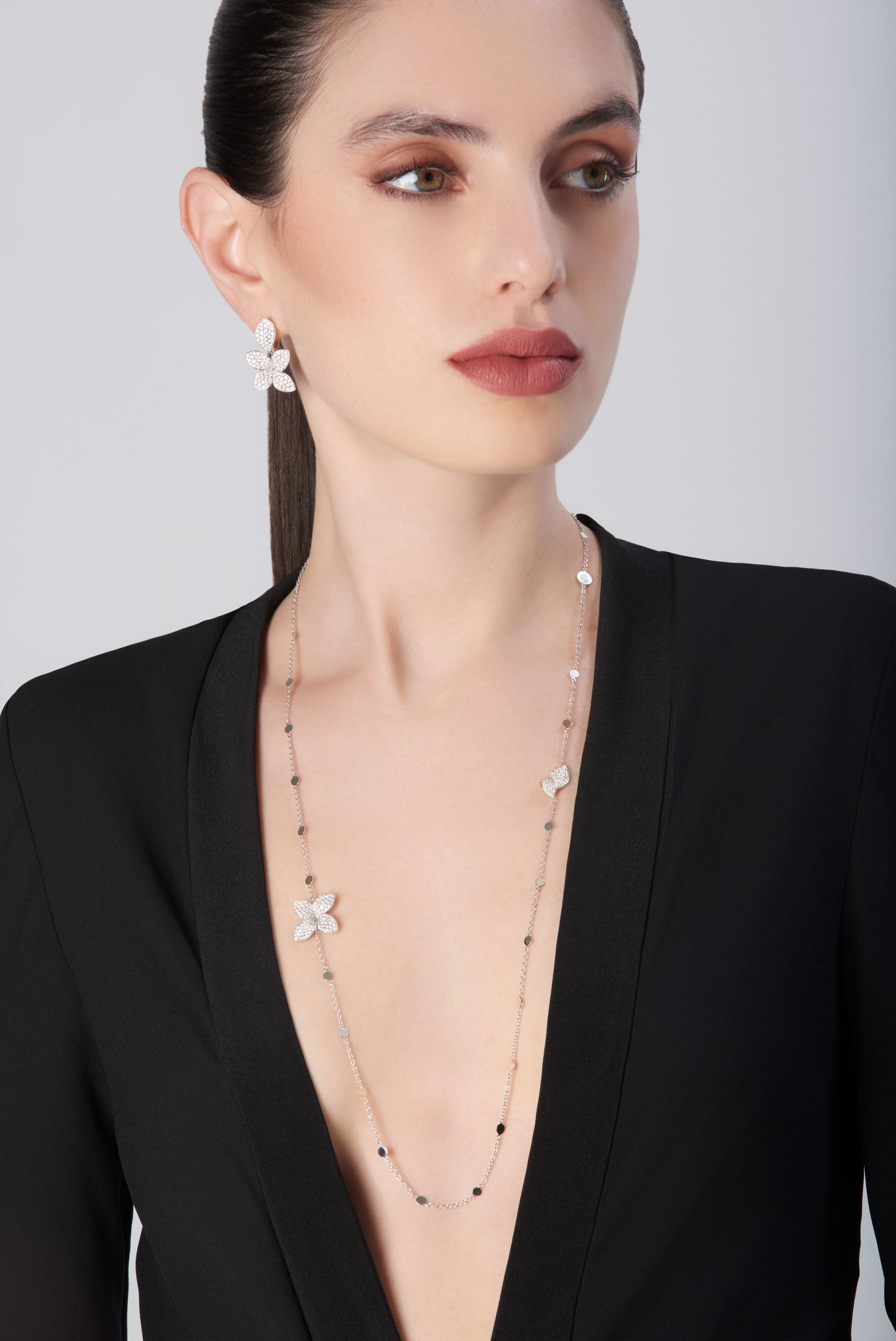 Sautoir in 18k white gold with diamonds and matching earrings on model dressed in black