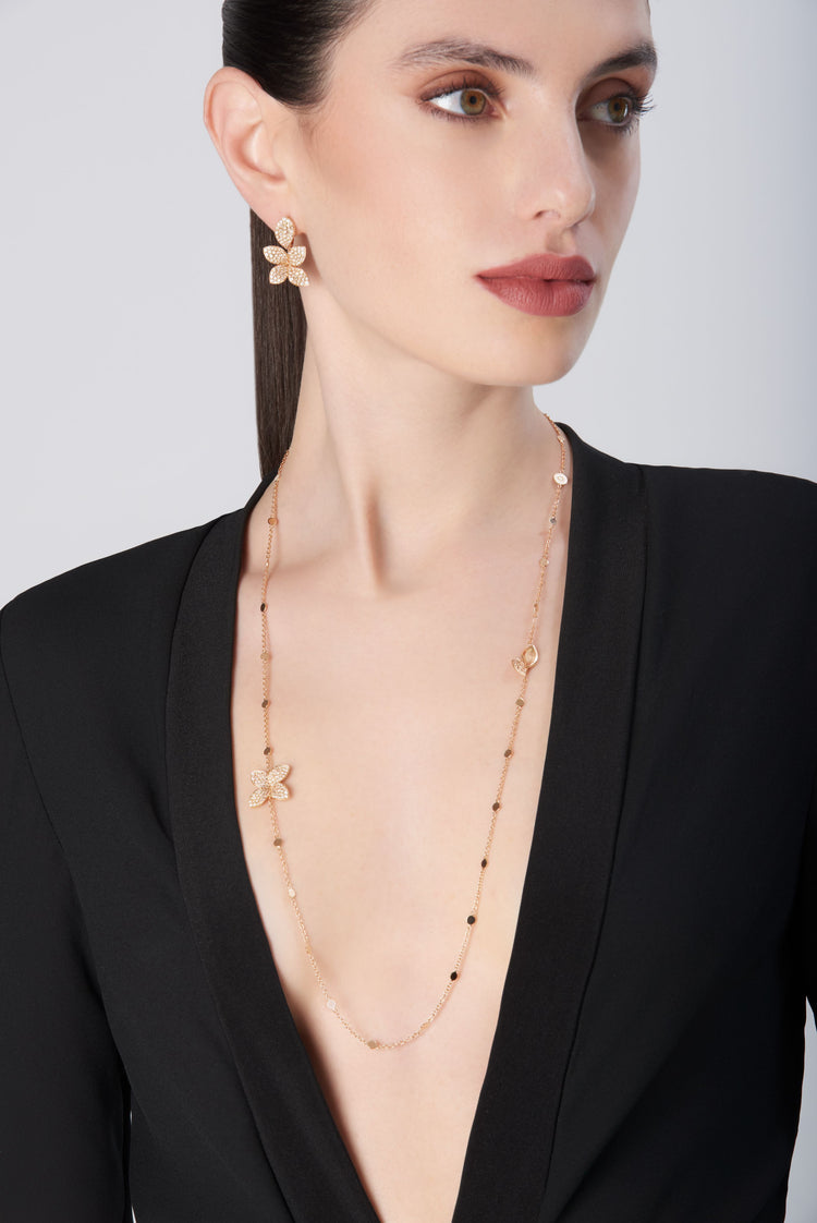Necklace and earrings in 18k rose gold with diamonds, worn by model in black dress
