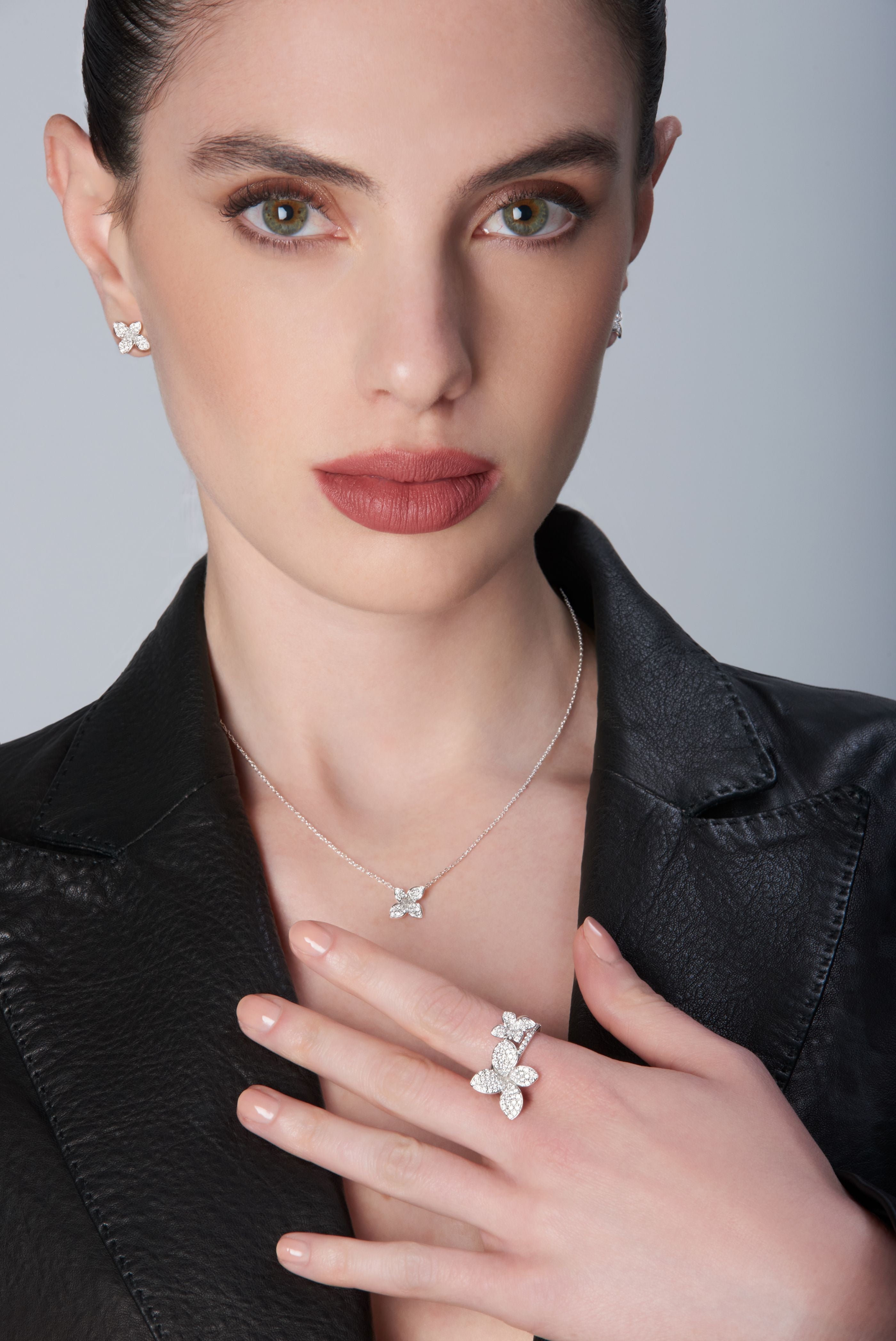 Necklace, earrings and rings in 18k White Gold with White Diamonds on model wearing a black leather jacket