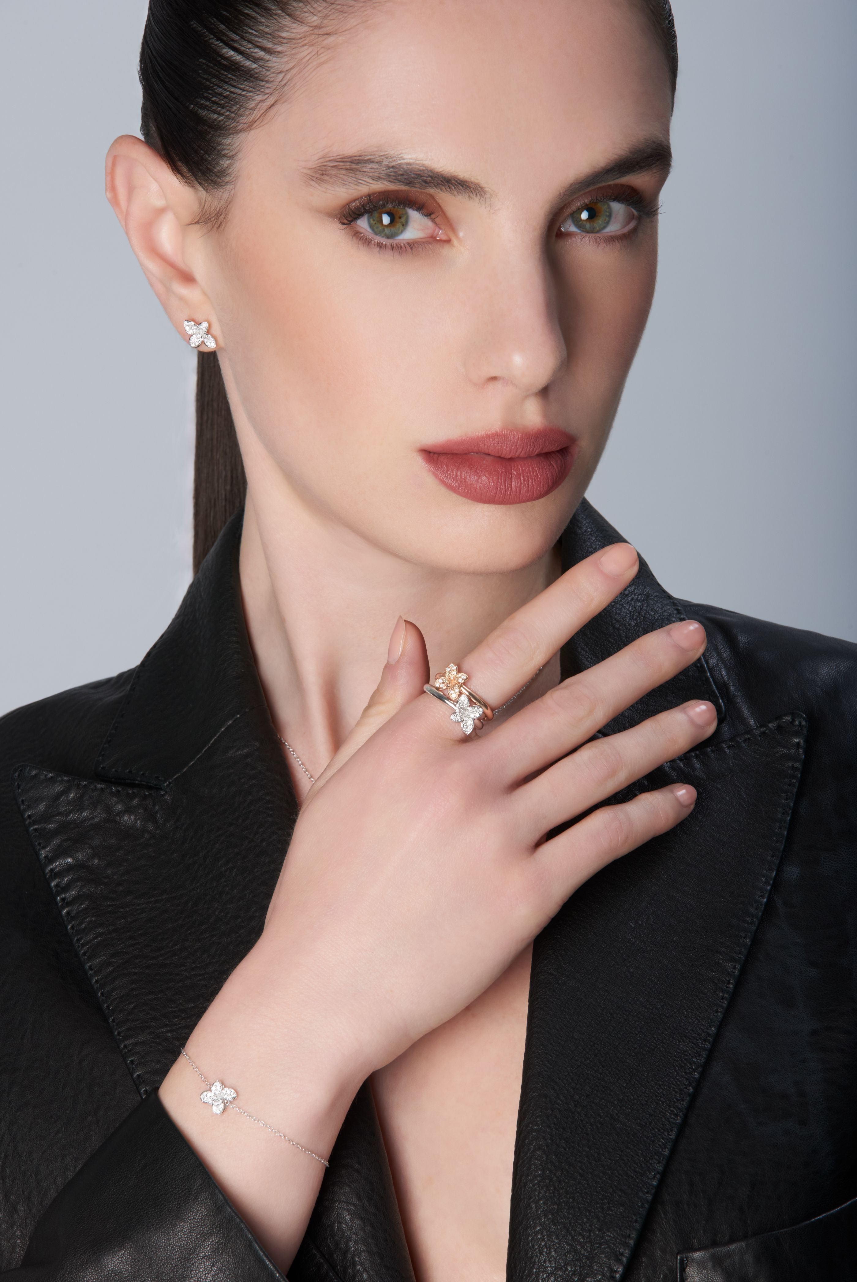 Earrings, ring and bracelet in 18k White Gold with White Diamonds and one ring in 18k Rose Gold with Diamonds wearing black jacket