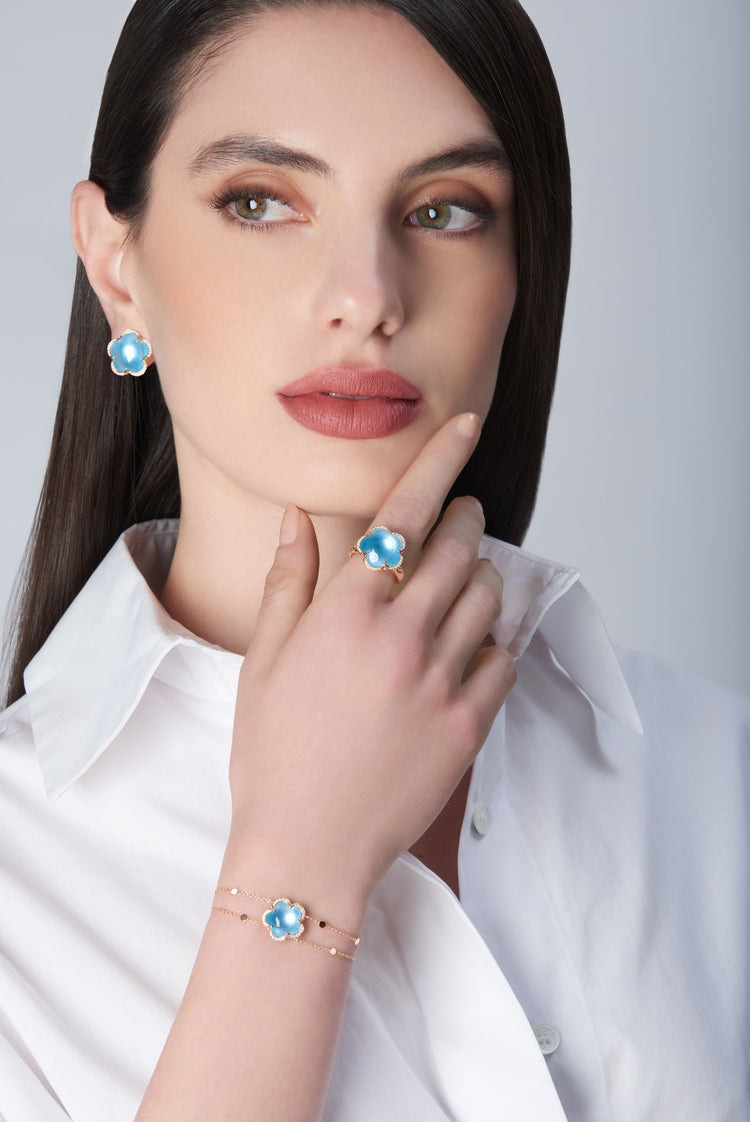 Earrings, ring and bracelet and earrings in 18k Rose Gold with Venus Blue Topaz and White Diamonds on model with white shirt