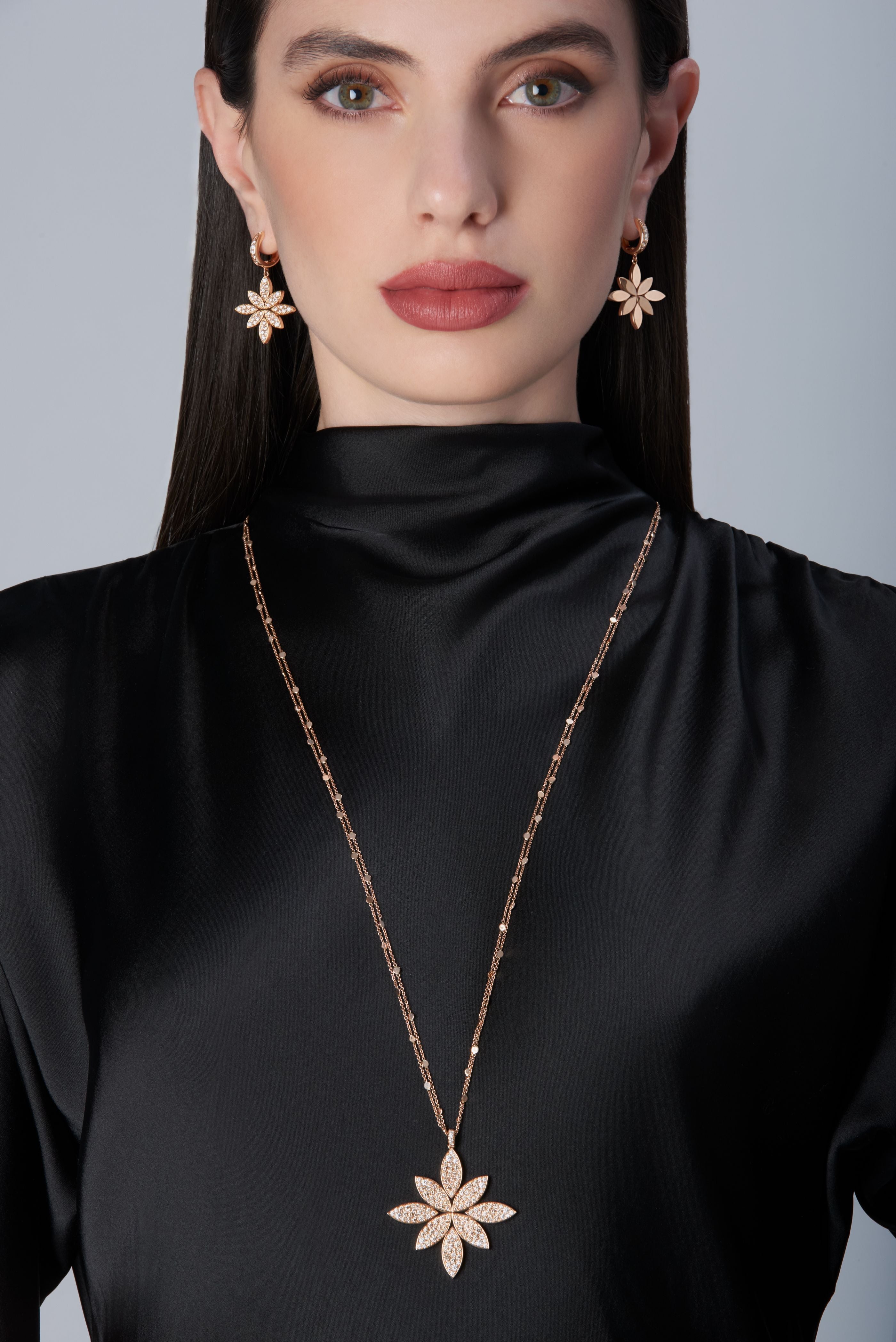 Woman wearing a black outfit with gold earrings and necklace