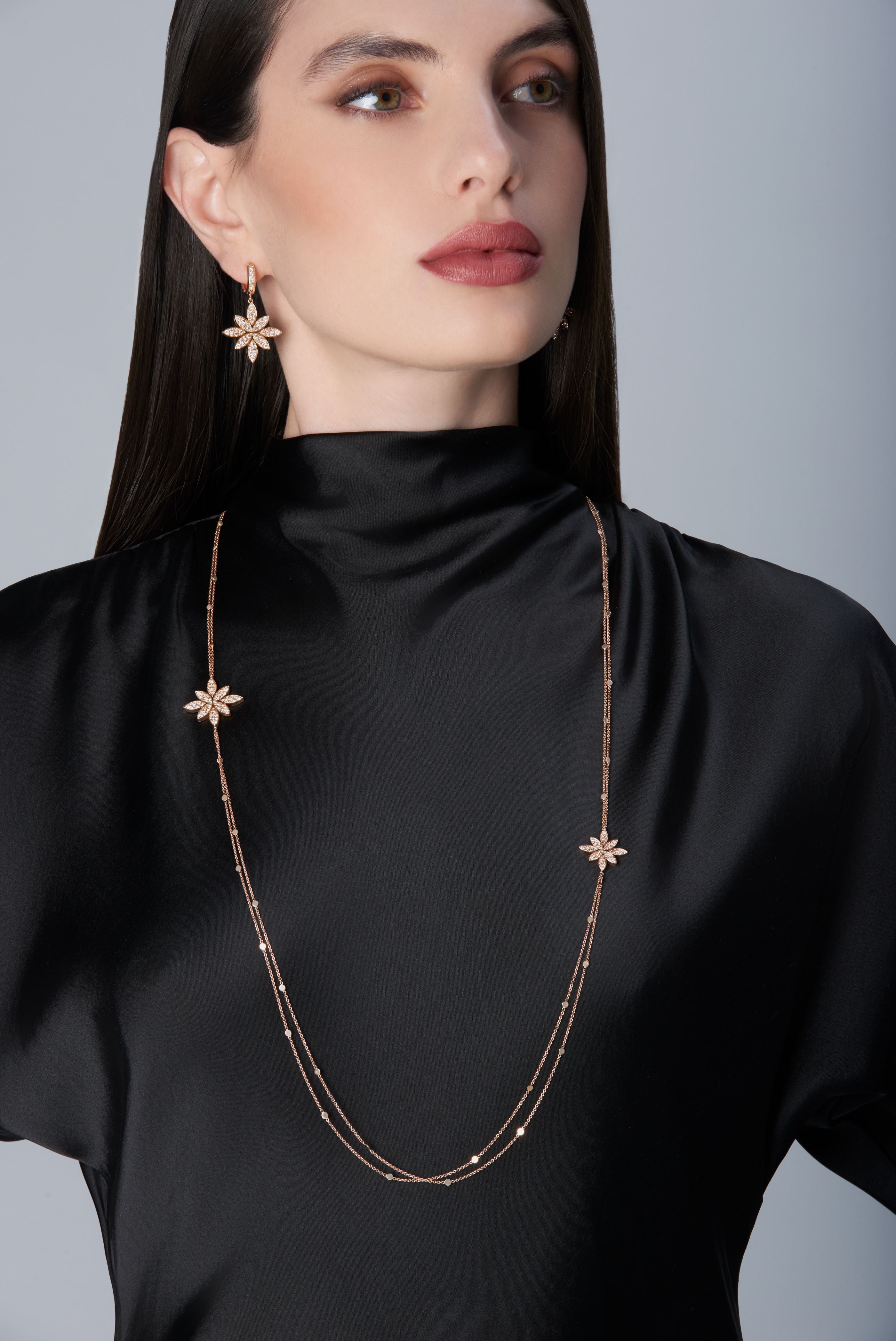 Model wearing a black dress and Sautoir and earrings in 18k Rose Gold with Diamonds