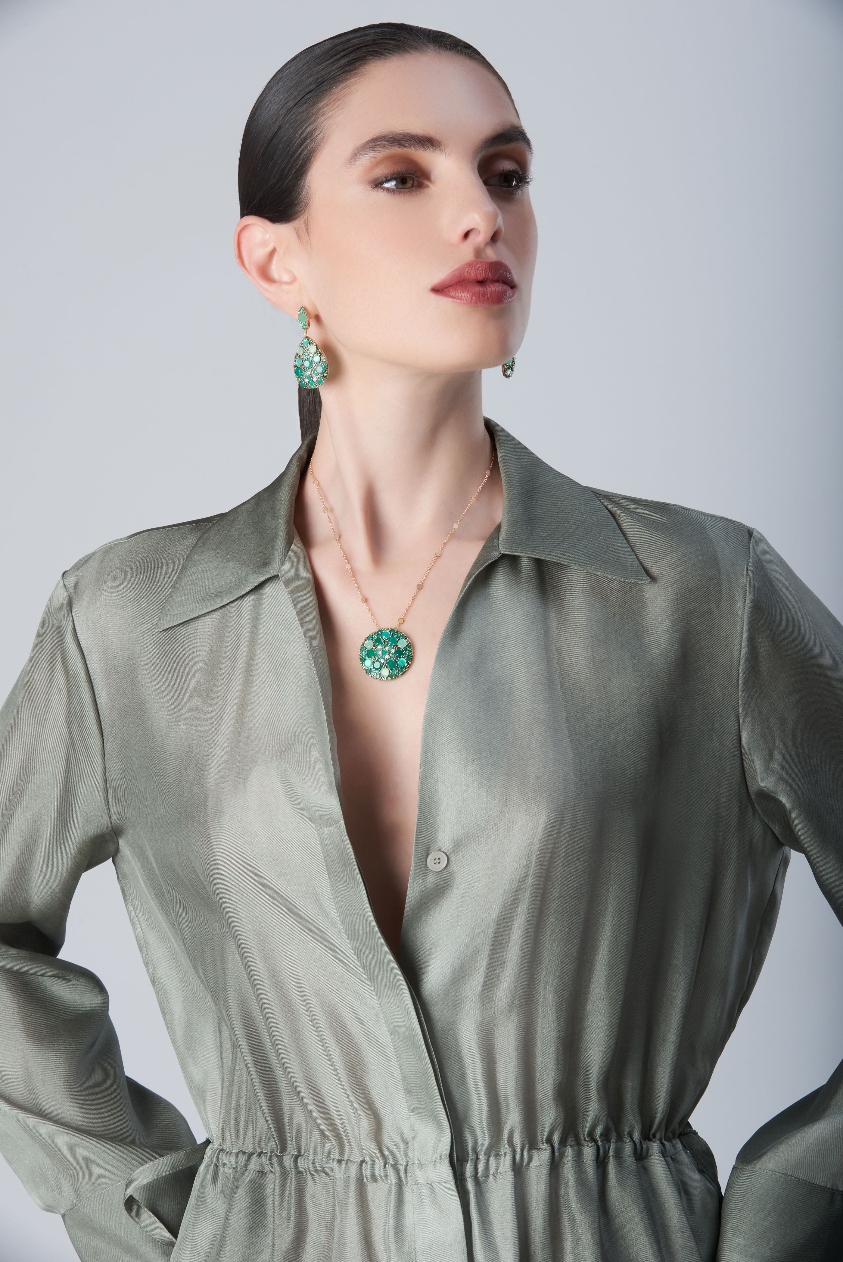 Earrings and necklace with Green Velvet, diamonds and green gemstones on model with a green dress
