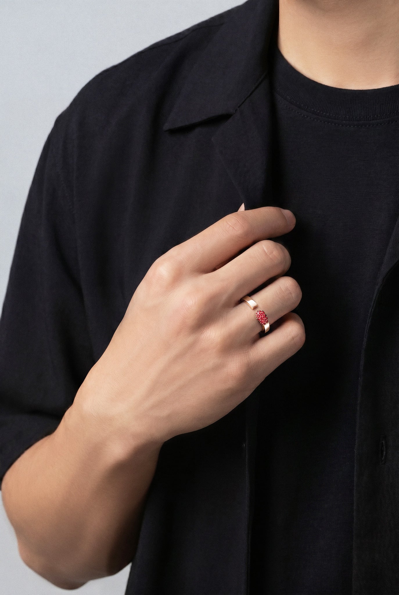 Model wearing a Ring in 18k Rose Gold with Rubies and a black shirt