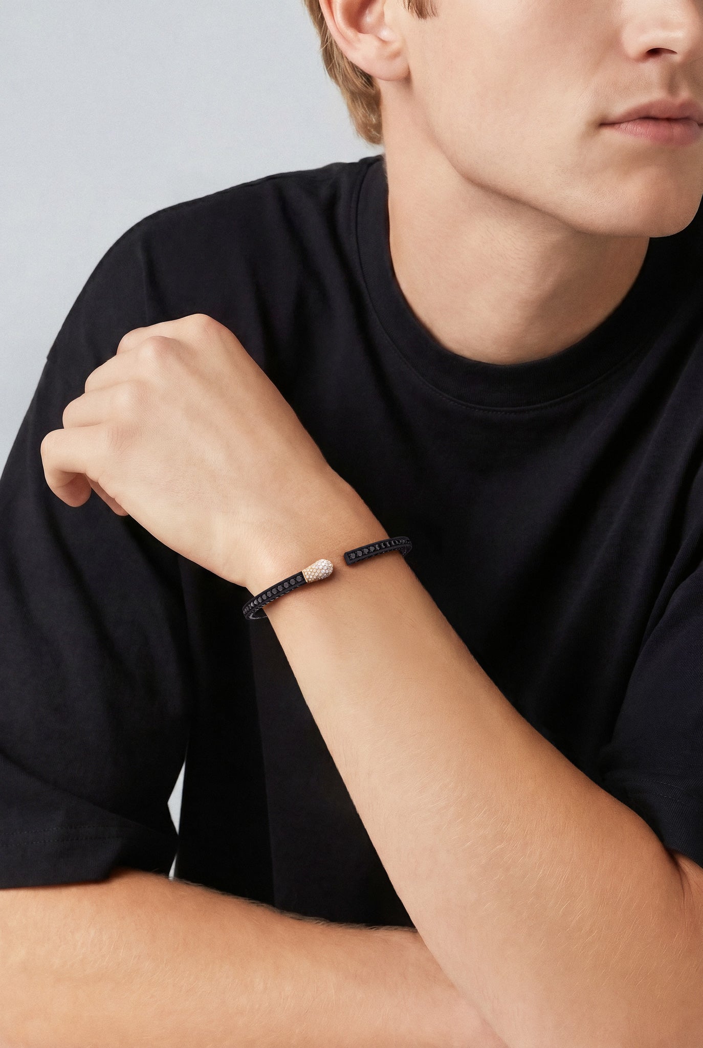 Model with a black shirtwearing a Bracelet in 18k Rose Gold and Black titanium with white, black and champagne diamonds