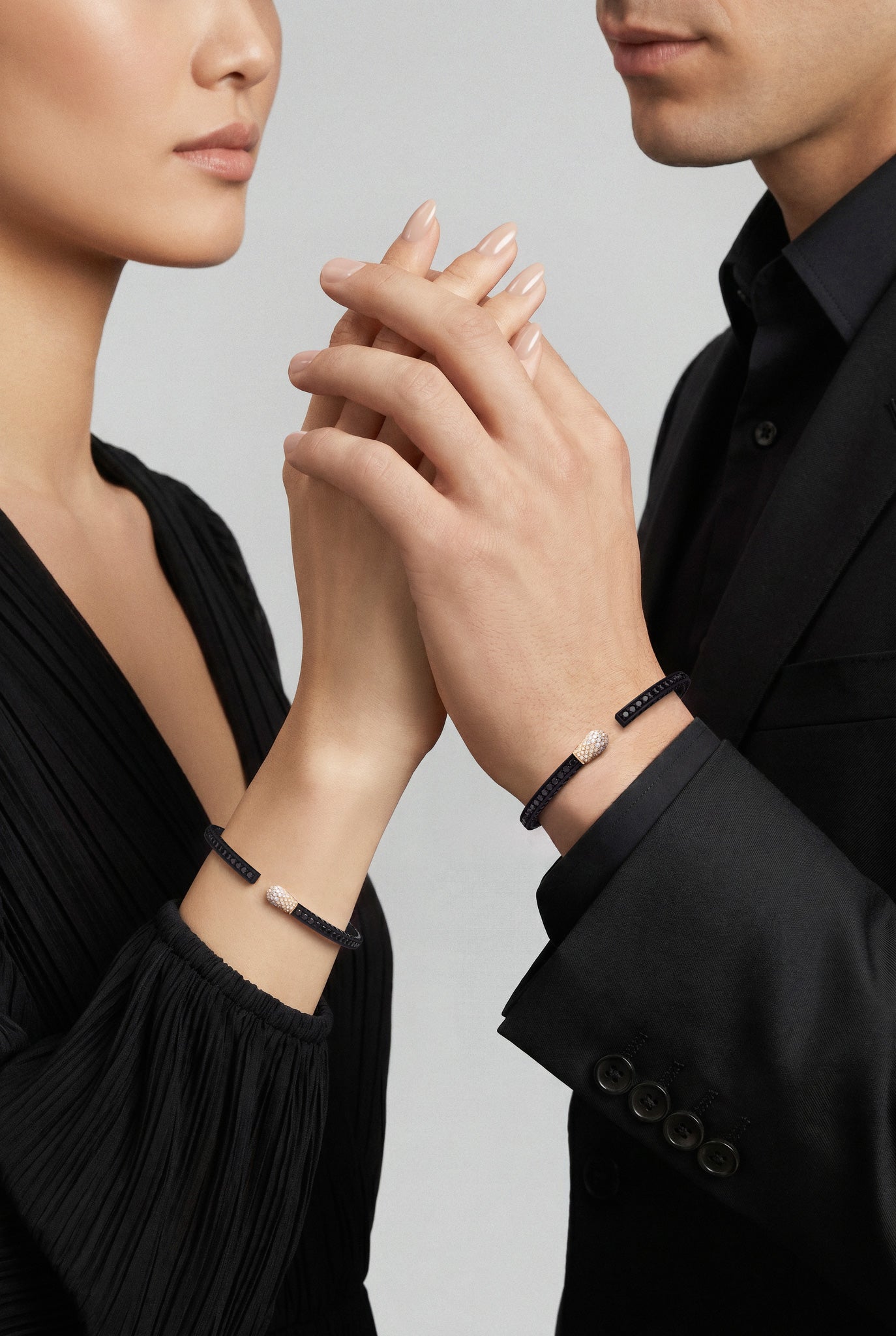 Models with black outfits wearing Bracelets in 18k Rose Gold and Black titanium with white, black and champagne diamonds