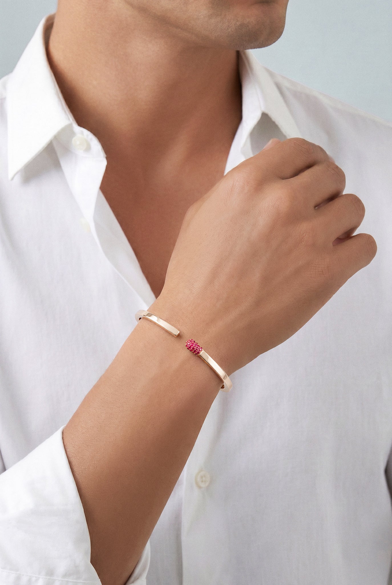 Model wearing a white shirt and a Bracelet in 18k rose gold with rubies