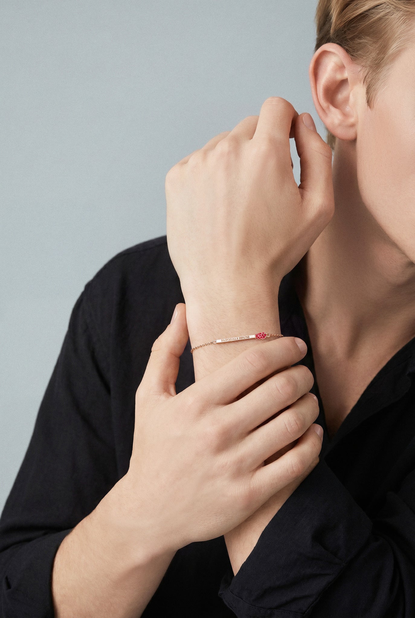 Model wearing a Bracelet in 18k rose gold with rubies and black shirt