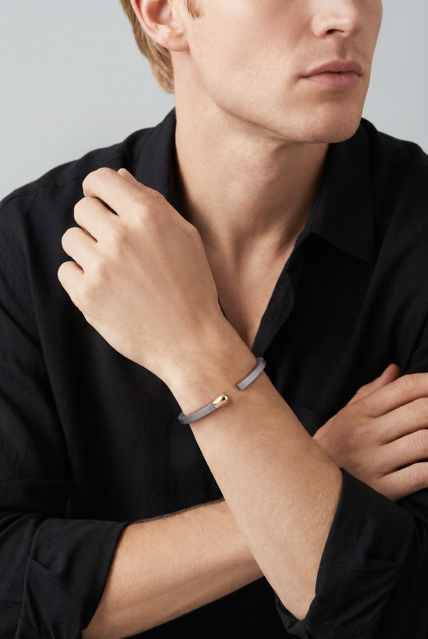Model wearing a black shirt and Bracelet in 18k Rose Gold and Grey Titanium