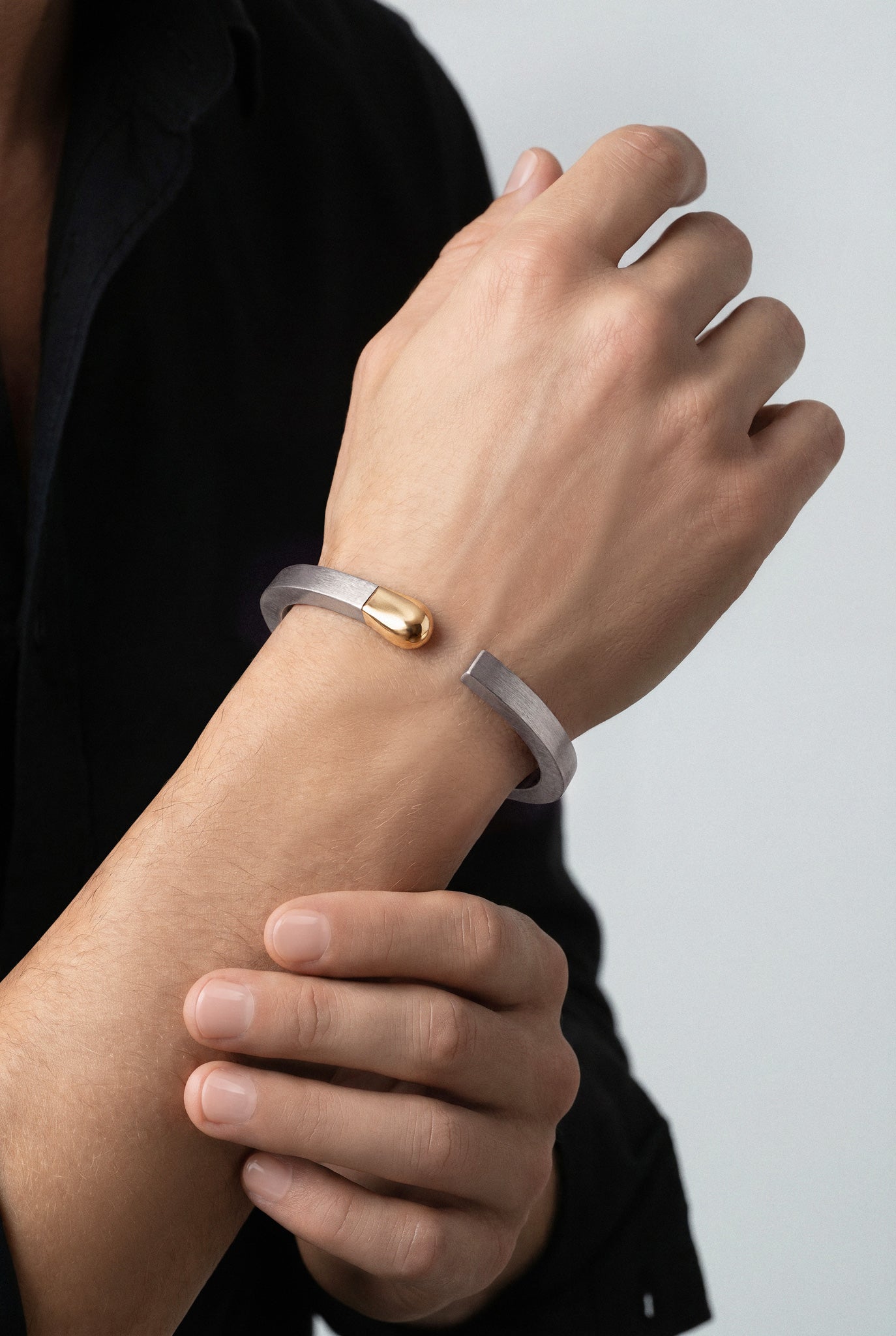 Model wearing a black shirt and a Bracelet in 18k Rose Gold and grey titanium