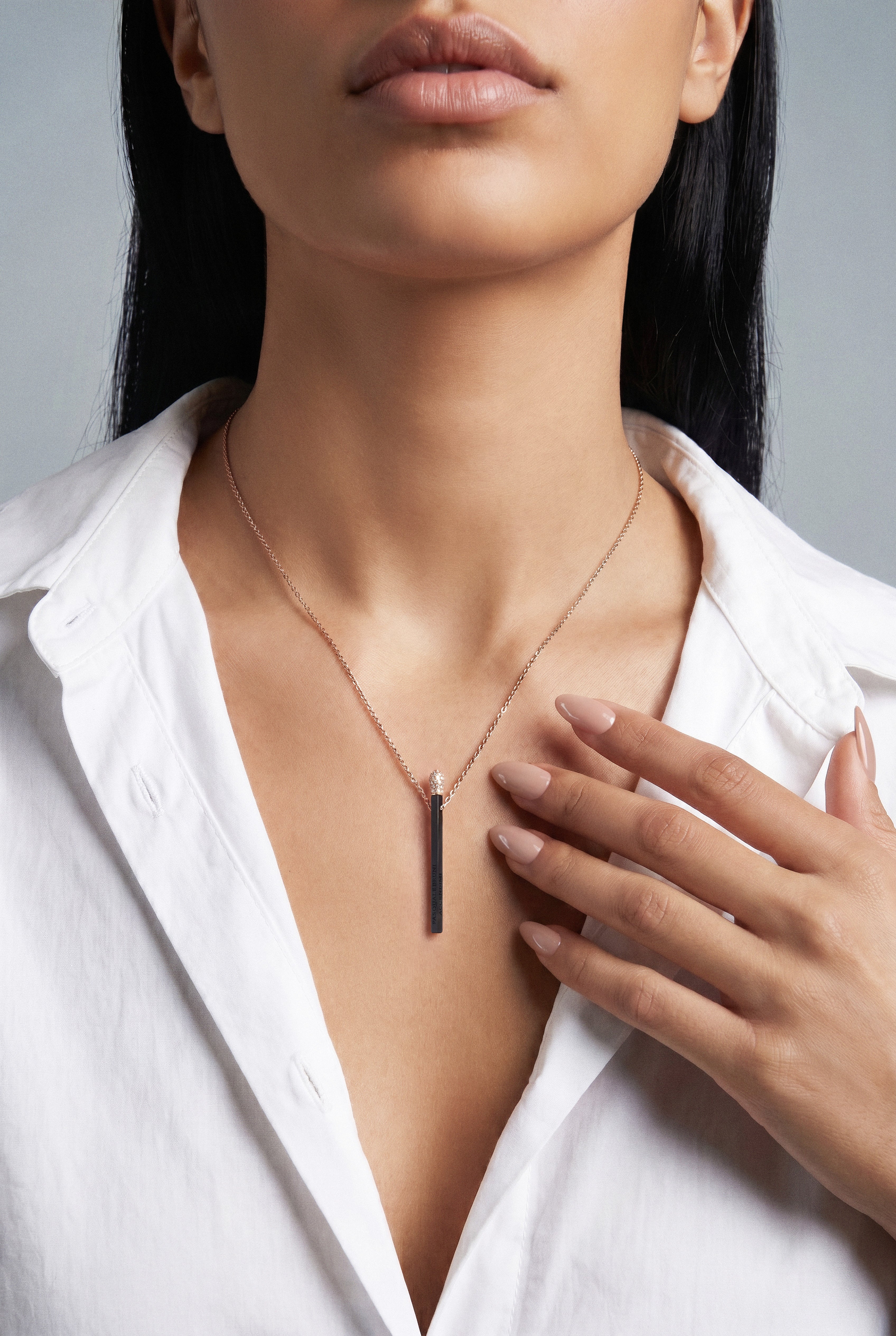 Model wearing a white shirt and Necklace in 18k Rose Gold and Black titanium with white and champagne diamonds